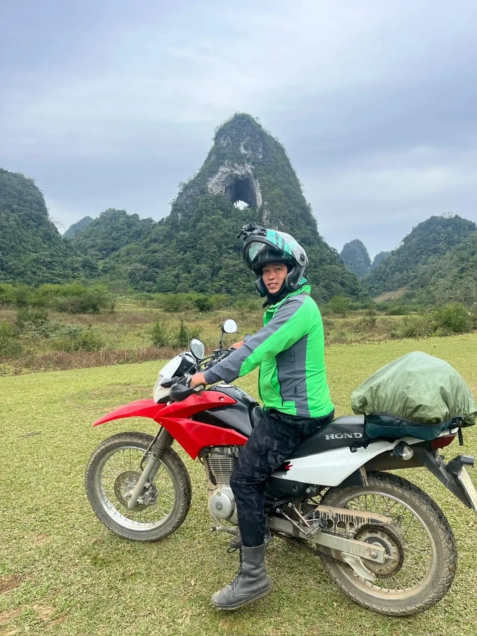 A traveller riding pillion behind a local Easy Rider on a Ha Giang Loop mountain road